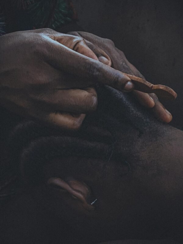 Detailed close-up of hands braiding hair, emphasizing texture and artistry.